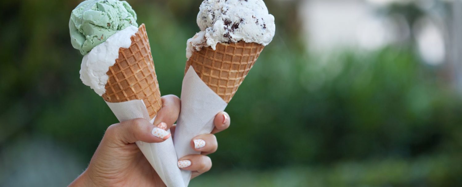 Person holding two ice cream cones.