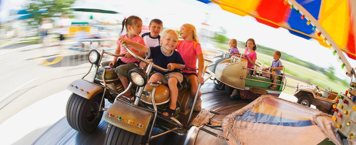 Kids on a ride at an amusement park.