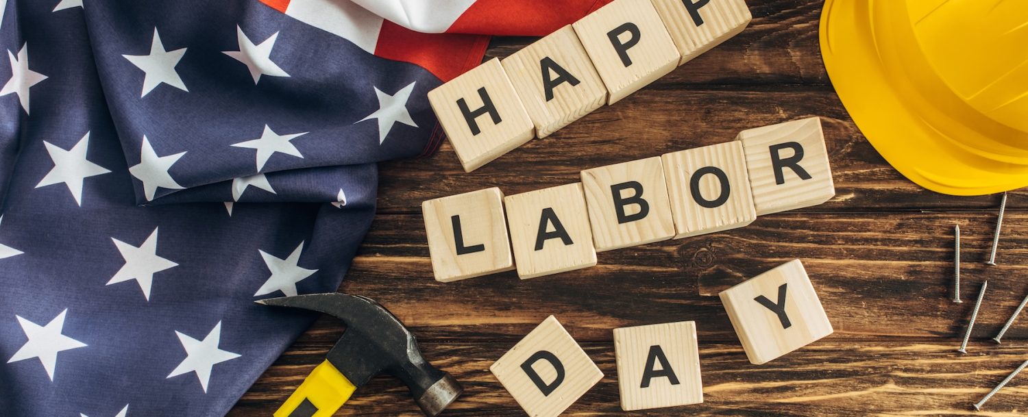 top view of american flag and instruments near safety helmet and happy labor day lettering on wooden surface