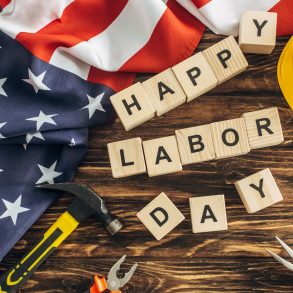 top view of american flag and instruments near safety helmet and happy labor day lettering on wooden surface