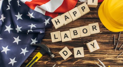 top view of american flag and instruments near safety helmet and happy labor day lettering on wooden surface