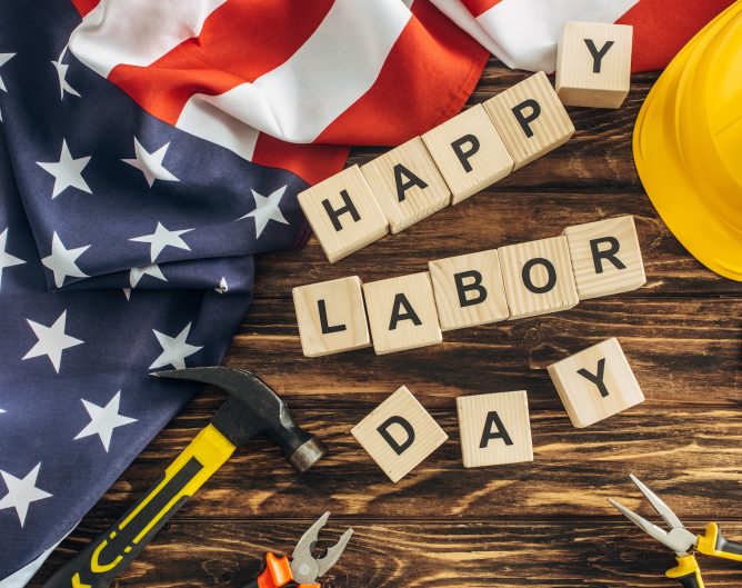 top view of american flag and instruments near safety helmet and happy labor day lettering on wooden surface